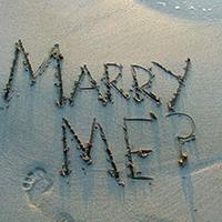 Marry me written in the sand at the beach