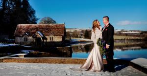 Winter Wonderland - Bride and Groom pictured by the River Tamar with Bathing Hut in background